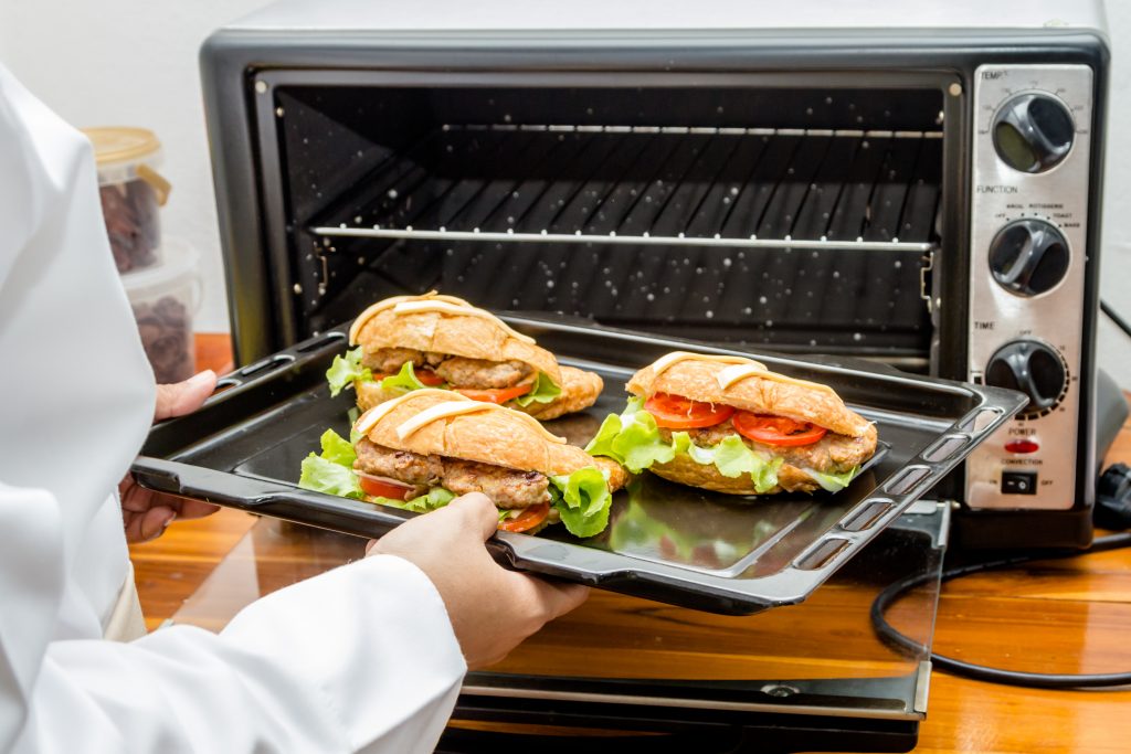 Chef taking food out a small convection oven toaster