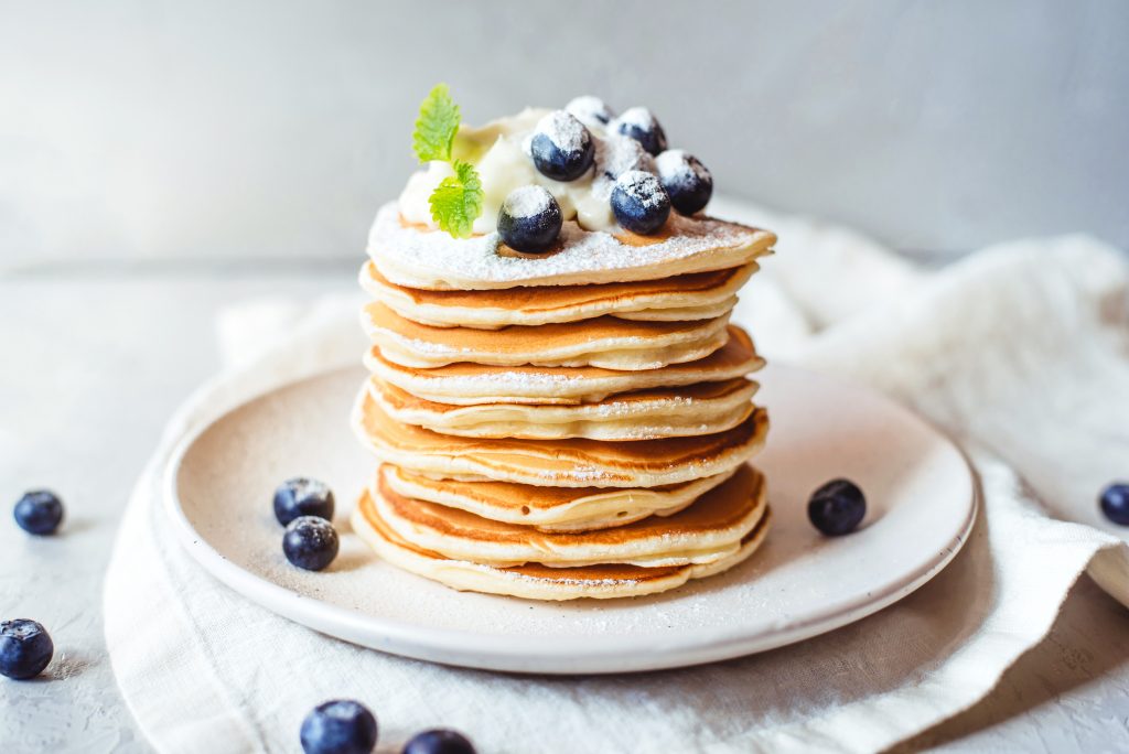 Image of pancakes piled up on a plate suggesting a healthy protein breakfast.